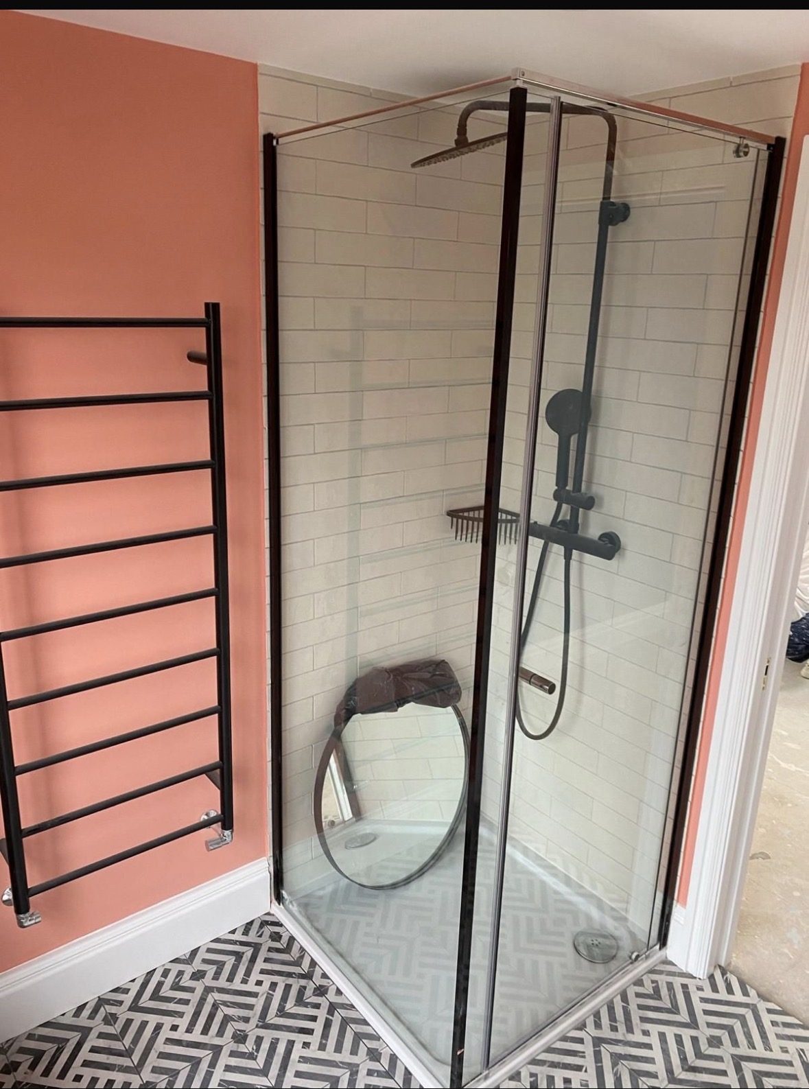 Corner walk-in shower in white metro tile with black fittings